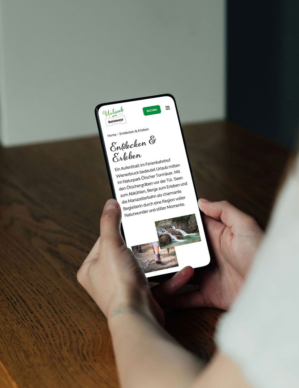 Smartphone in der Hand mit der mobilen Ansicht von Urlaub am Bahnhof