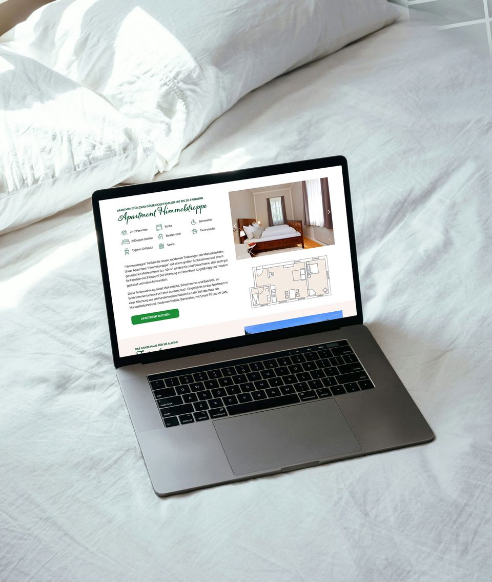 Laptop auf einem Bett mit der Apartment-Seite von Urlaub am Bahnhof